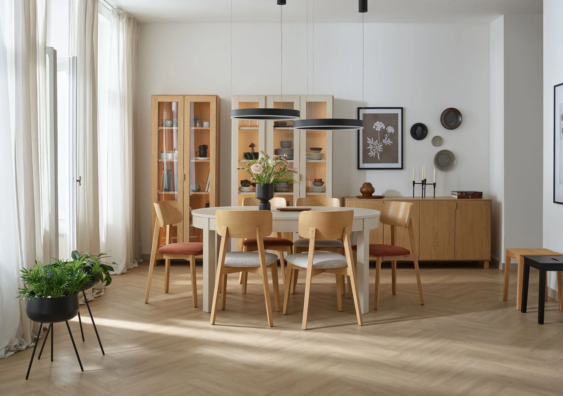 Salon z jadalnią z okrągłym stołem i drewnianymi witrynami